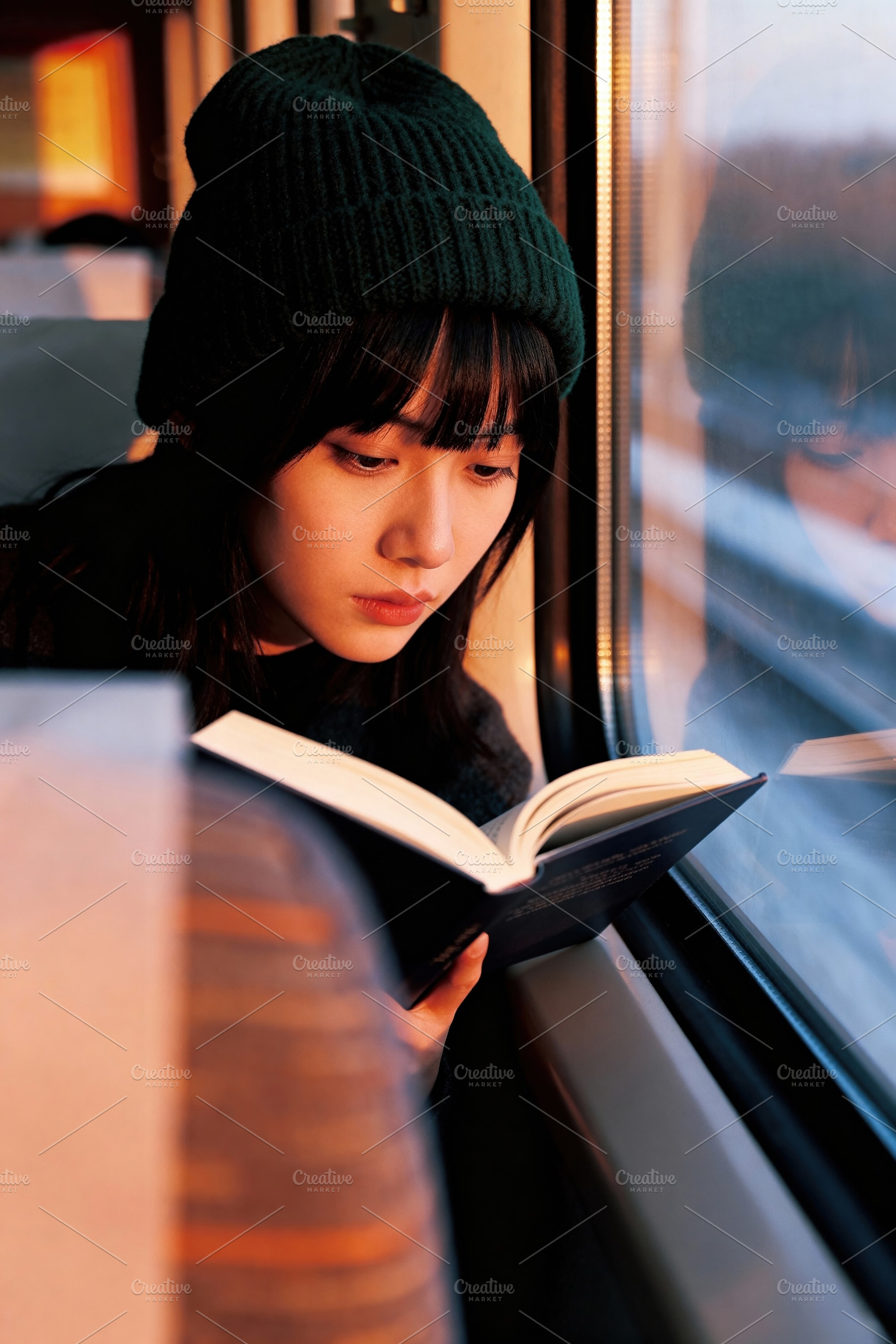Young Woman Reading on a Train, a Person Photo by Virgo Studio