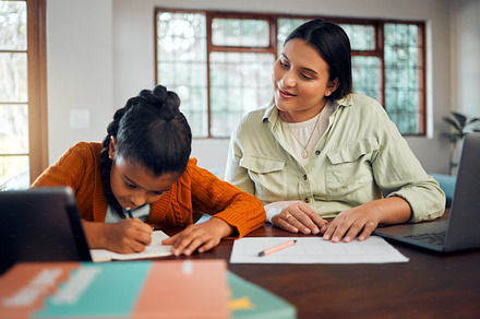 Child, homework and learning with mother while writing in notebook for virtual education class at table at home with support, care and supervision. Woman helping girl with school work in house, a Photo by Peopleimages.com