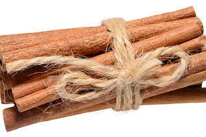 Dry cinnamon sticks tied with twine on isolated background, a Food & Drink Photo by ndanko