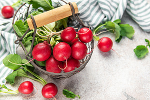 Fresh radishes with green leaves in metal basket, a Food & Drink Photo by Olena Rudo