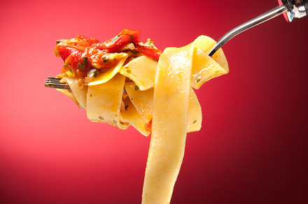 Tagliatelle with clams on a red background