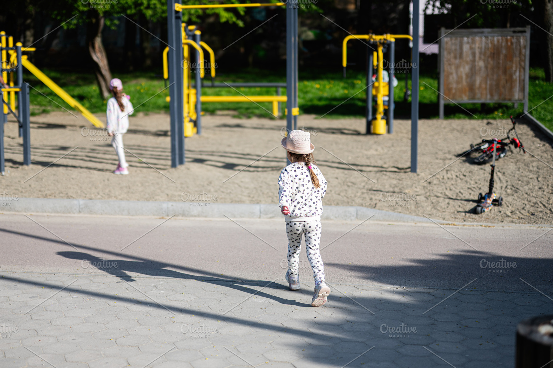 Young girl exploring a playground area with outdoors fitness equipment, a Person Photo by AS photostudio