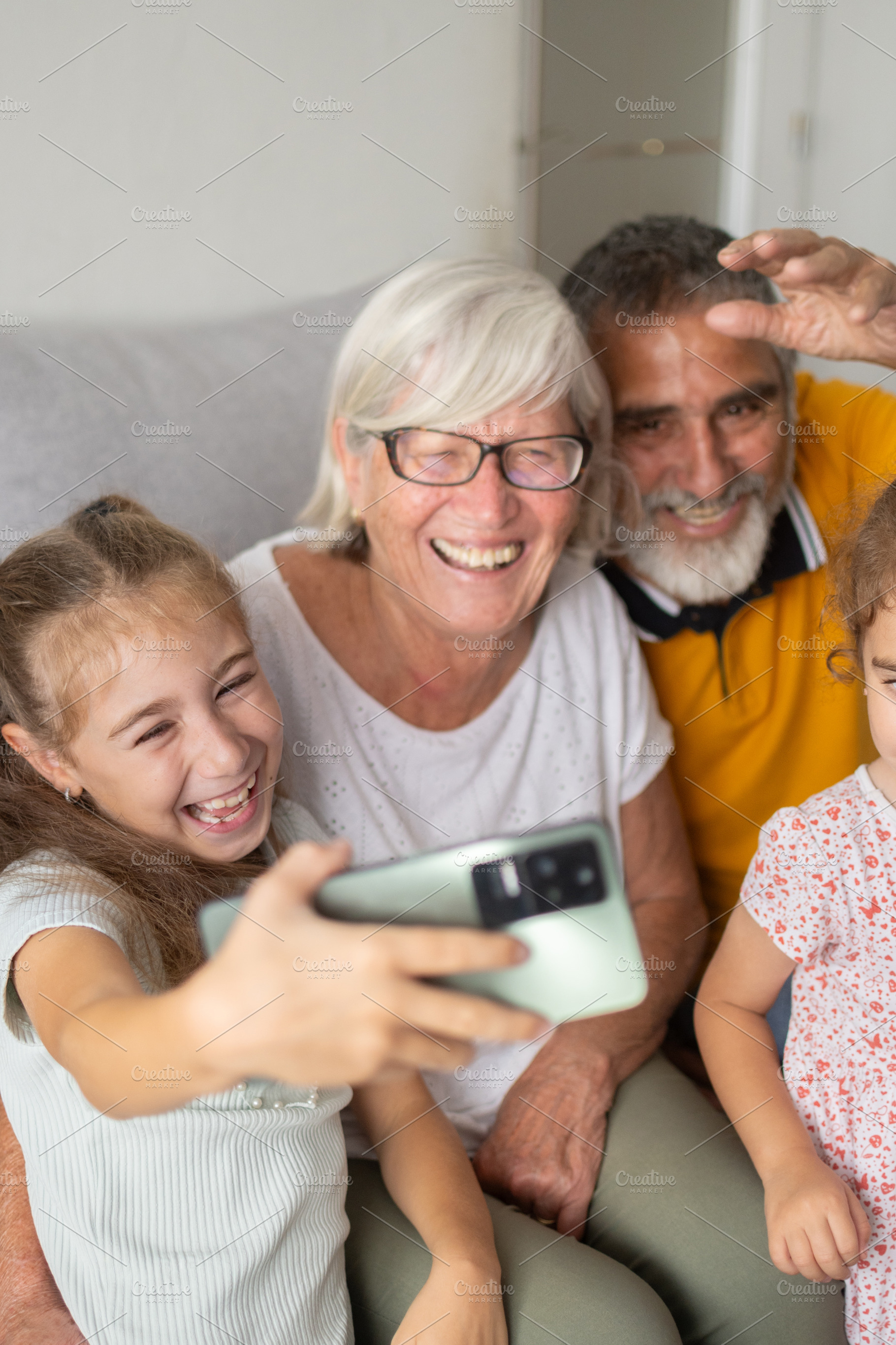 Happy grandparents and grandchildren taking a selfie together at home, a Person Photo by etorres69