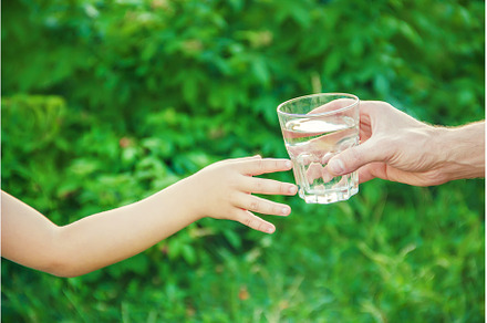 The father gives the child a glass, a Food & Drink Photo by yanadjana