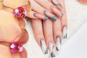 Woman's hands receiving professional manicure on towel with orch, a Beauty & Fashion Photo by Olena Rudo