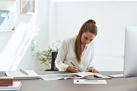 Young female architect working on a draft in an office, a Business Photo by Stefan & Janni