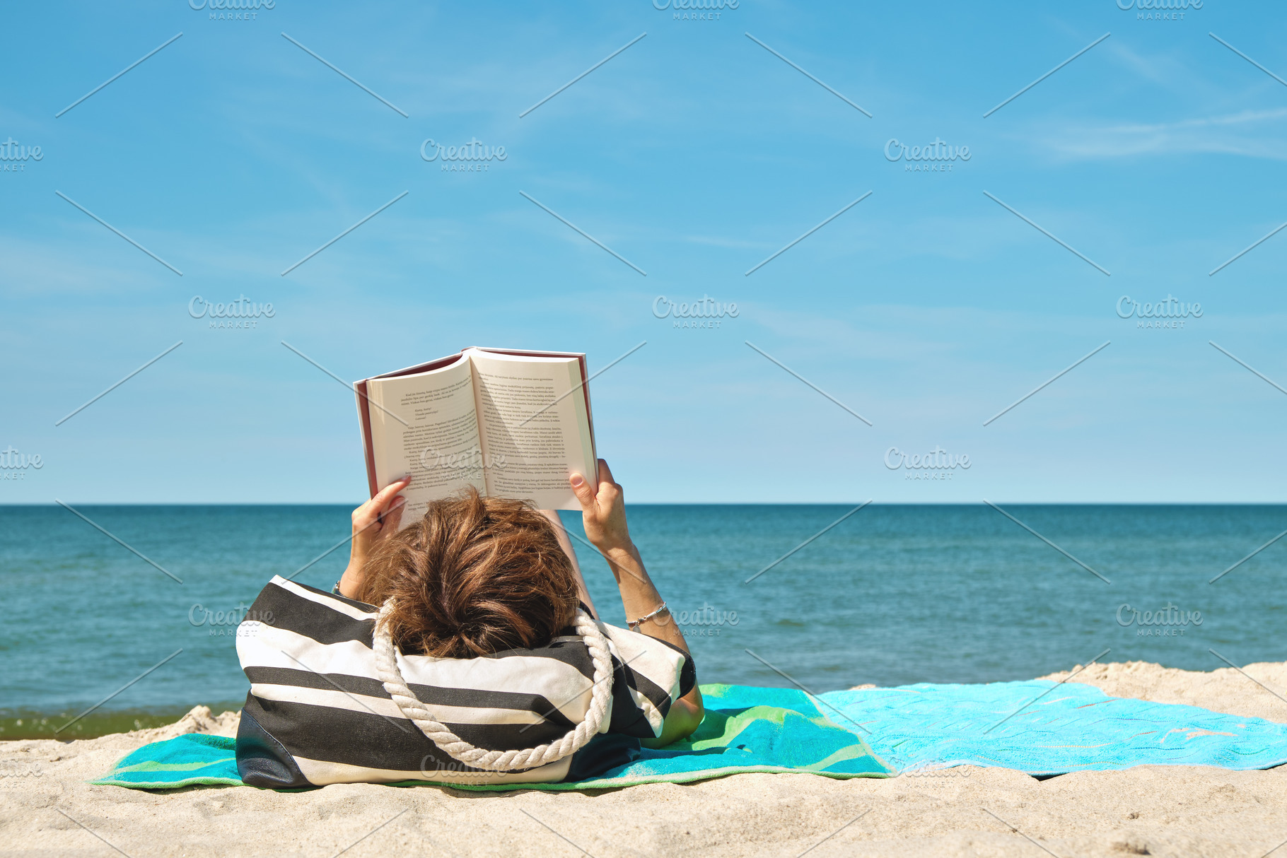 Woman on the beach with book, a Person Photo by BOOCYS