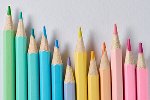 A row of colored wooden pencils with sharp tips on a white backg, an Abstract Photo by ndanko