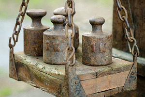 Close-up view highlights the textured wood and rusted chains of an antique bala, an Industrial Photo by Rohan Photography