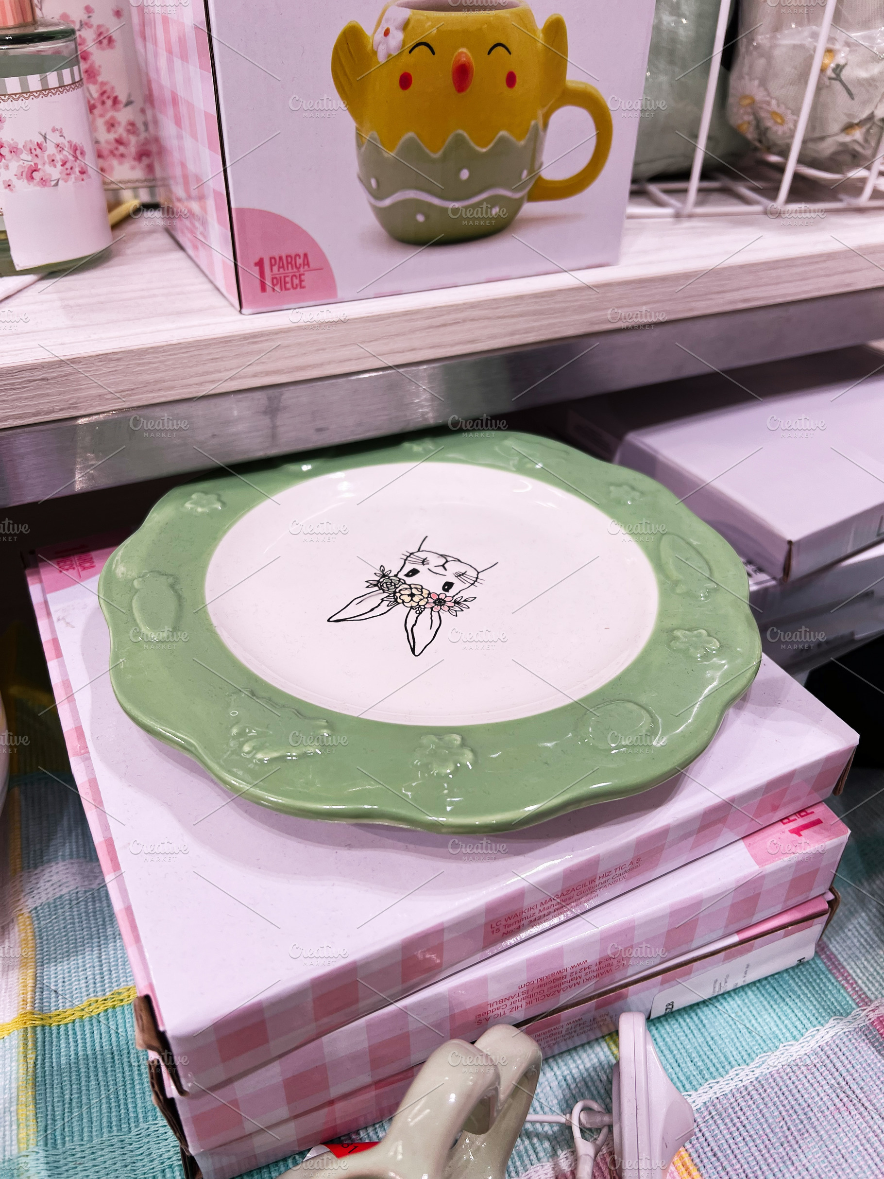 Decorative green rimmed plate showcased with cute mug on retailer shelf, a Photo by AS photostudio