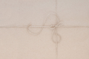 Cardboard packing with jute thread.