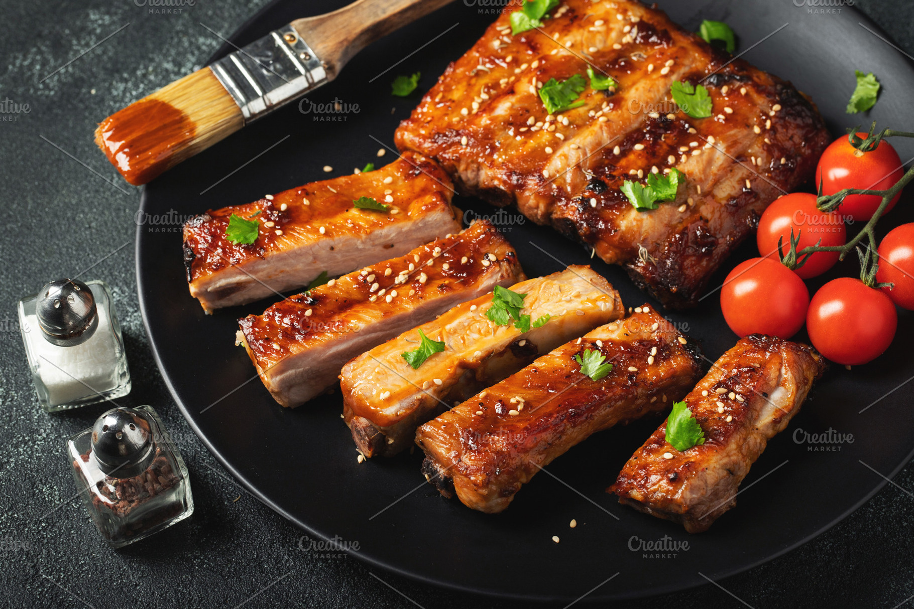 Hot grilled spare ribs from a summer BBQ served on a plate with, a Food & Drink Photo by Budarinphoto
