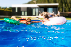 Childs playing in swimming pool containing pool, child, and kids