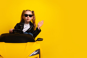 Stylish young girl wearing sunglasses and leather jacket drives, a Person Photo by Ales Munt