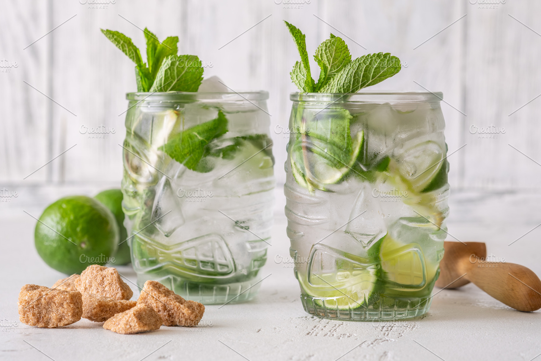 Two fresh mojito cocktails in tiki glasses with lime mint garnis, a Food & Drink Photo by Alexander Prokopenko