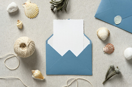 Wedding envelope with invitation card mockup inside and seashells on table. Sea, a Holiday Photo by photoguns