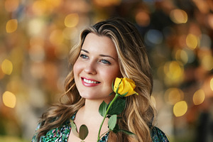 Beautiful woman holding a yellow rose, smiling and looking away,, a Person Photo by Studio ANNA