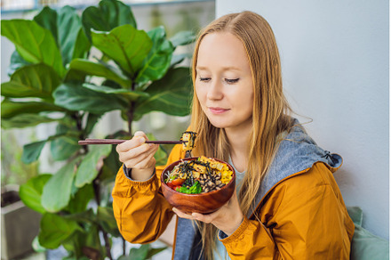Woman eating Raw Organic Poke Bowl, a Food & Drink Photo by Elizaveta Galitskaya