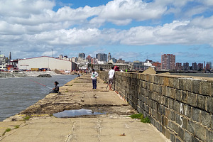 People walking and fishing on a long urban pier, montevideo, uru, an Architecture Photo by DanFLCreativo