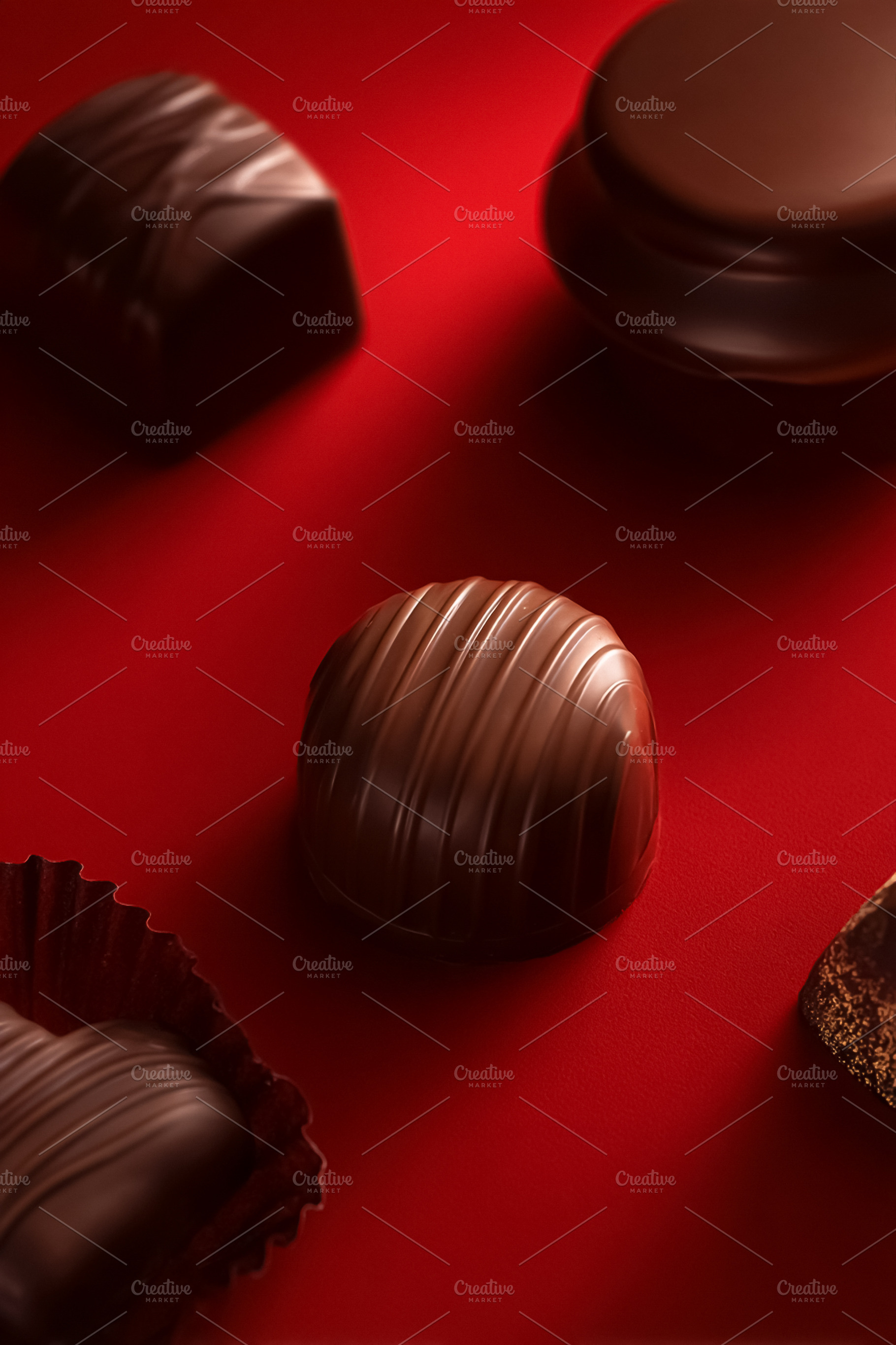 Chocolates and candies arranged on red, symbolizing love, desire, a Photo by Studio ANNA