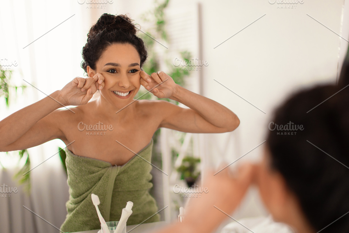 Lovely young woman making lymphatic drainage facial self massage near mirror at, a Photo by Prostock-Studio (Photo 1 of 2)