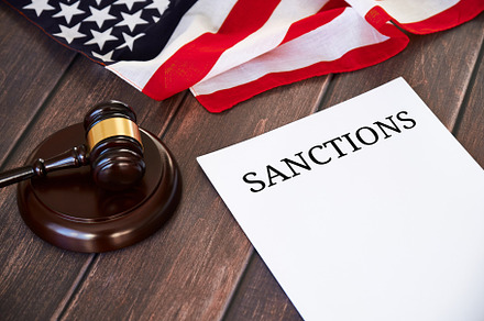 US sanctions list, United states flag and judge's gavel on wooden table., a Business Photo by photoguns