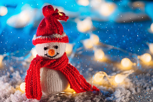 Funny knitted toy snowman. Christmas decor, fake snow decoration , bokeh garlan