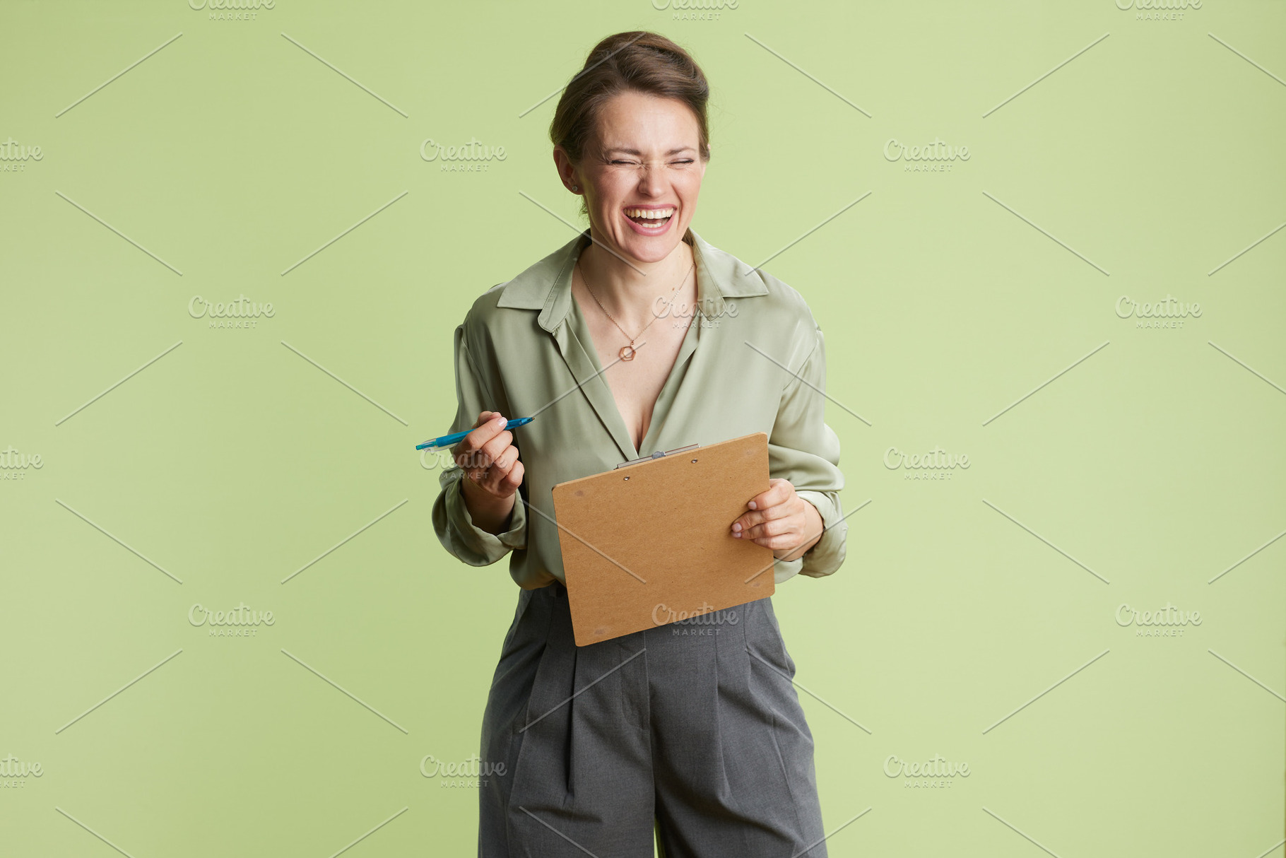 Laughing woman with clipboard, a Business Photo by Alliance Images