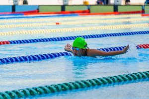 Swimmer child swims butterfly swimming style in a race swimming