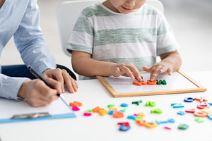 Cute little kid at speech therapist office. Close up of unrecognizable boy lear, a Photo by Prostock-Studio