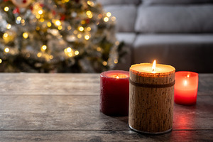 Red Christmas candles with holiday lights and tree in background, a Food & Drink Photo by etorres69
