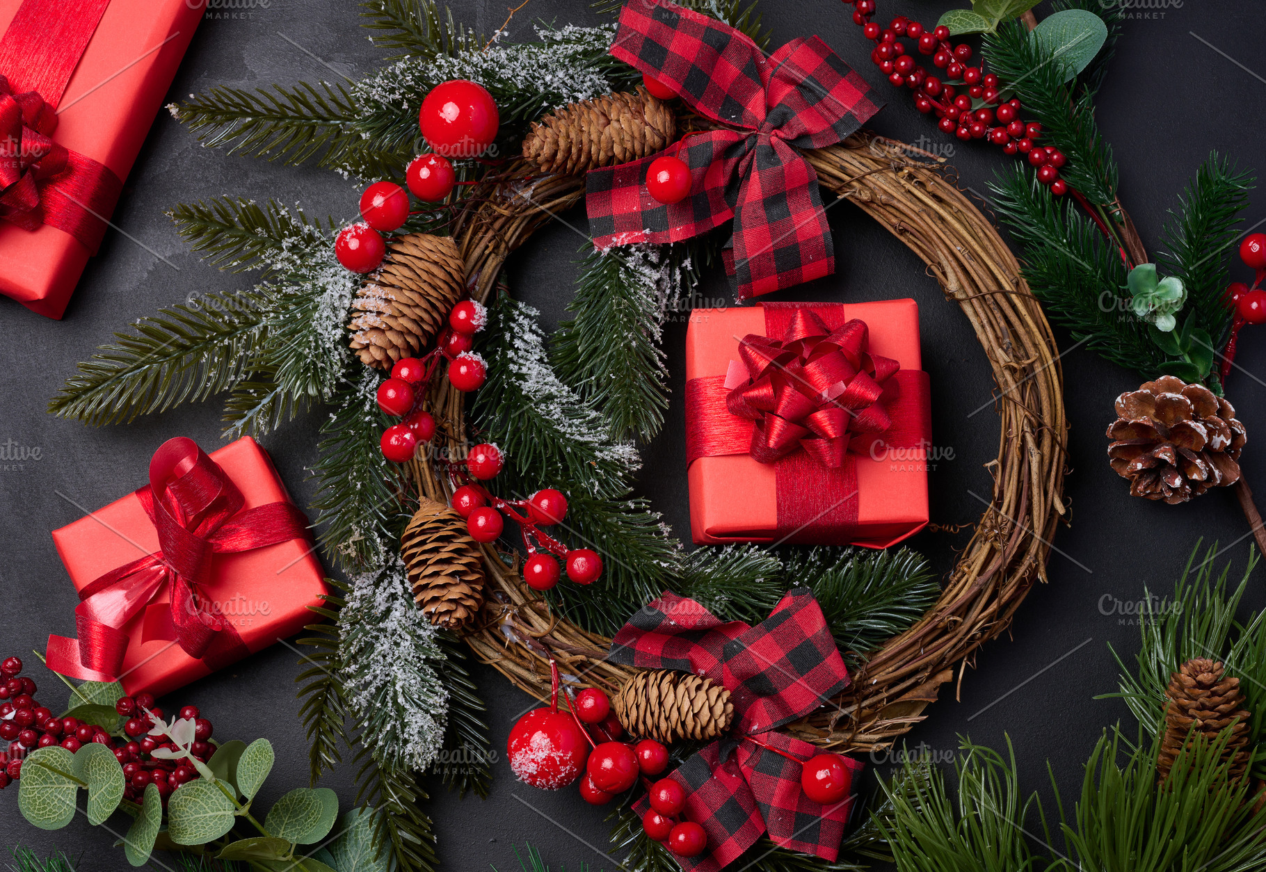 Christmas wreaths, fir branches and gifts on a black background., a Holiday Photo by ndanko