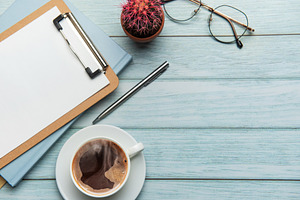 Office desk with coffee, clipboard, eyeglasses and cactus on woo, a Business Photo by Olena Rudo