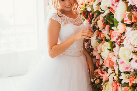 Beautiful bride on the background of a wall of flowers featuring wall