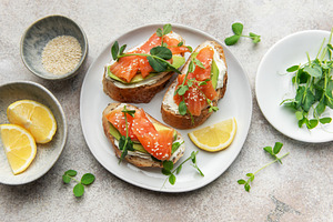 Salmon avocado toasts with microgreens and lemon, a Food & Drink Photo by Olena Rudo