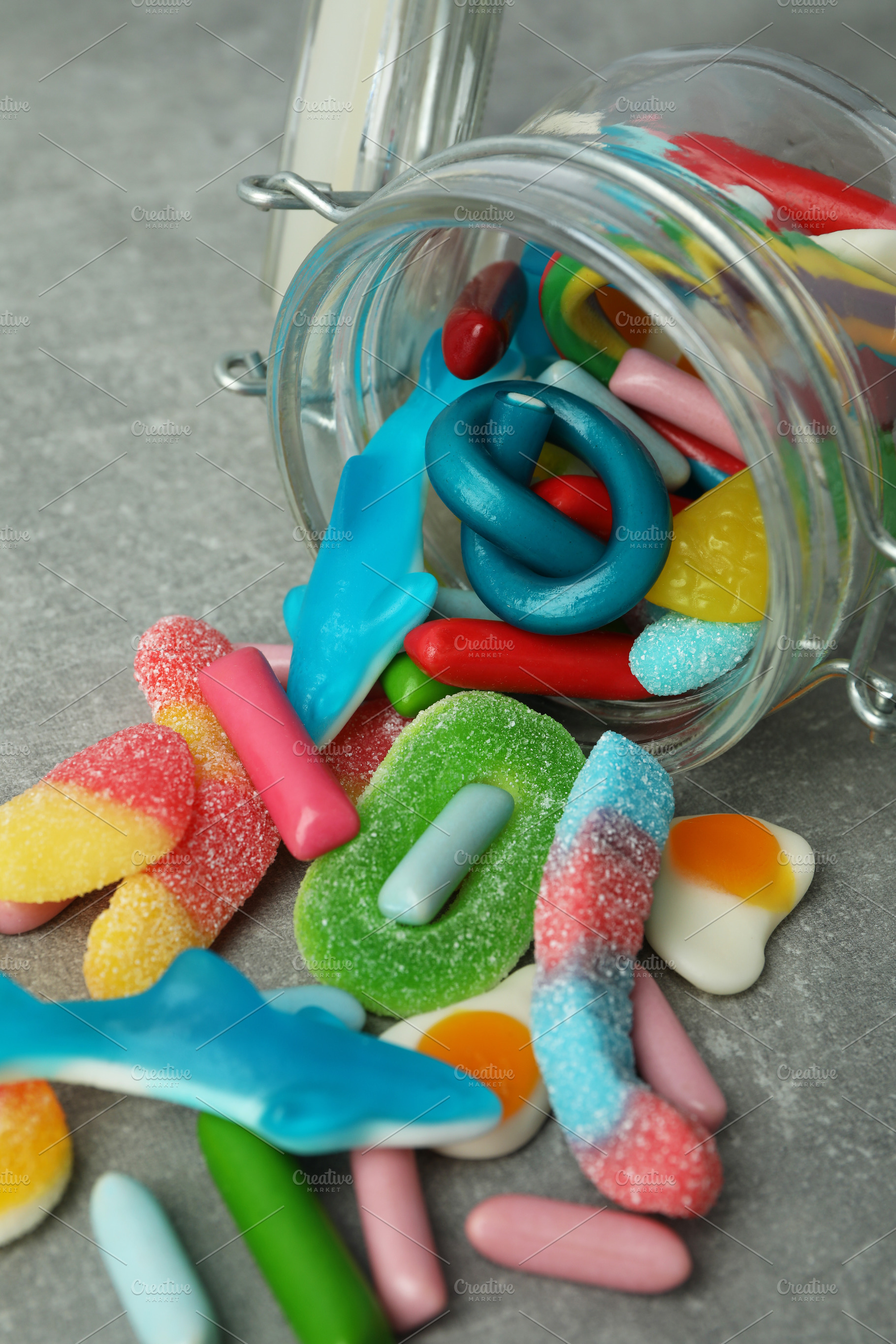 Jar with gummy candies on gray textured background, a Food & Drink Photo by AtlasStudio PRO