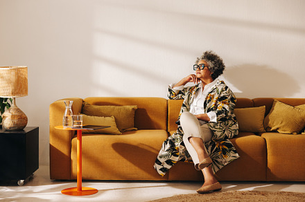 Pensive businesswoman sitting on a couch in an office lobby, a Person Photo by Jacob Lund