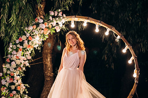 blonde bride in a light coral dress against the backdrop of an e, a Person Photo by Weddings, People, Travel