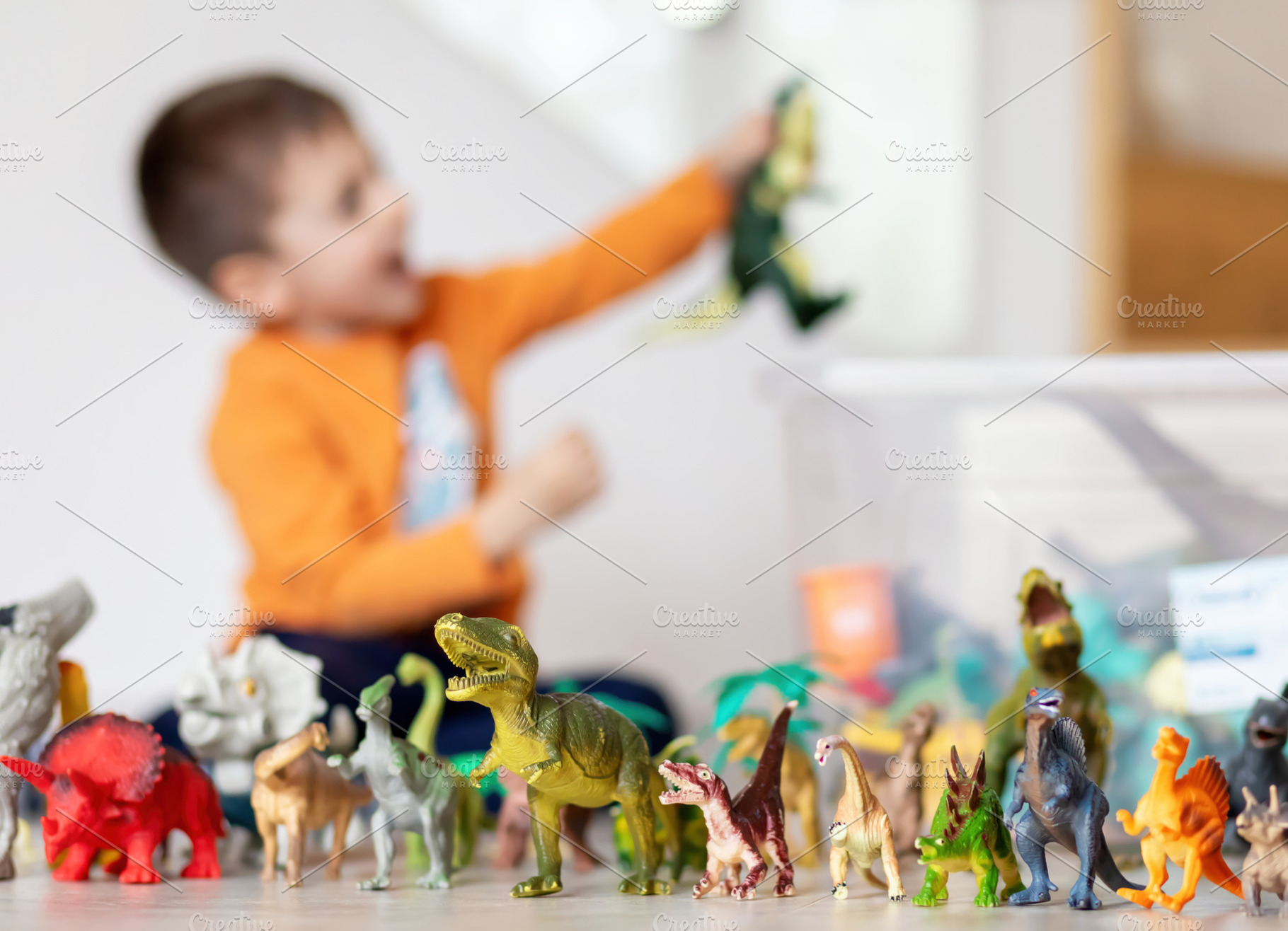 Child playing with dinosaur toys, selective focus on toys, a Person Photo by Antonio Gravante Market
