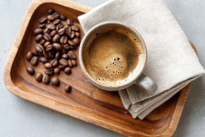 Freshly brewed coffee served in a handmade cup with roasted beans on a wooden t, a Food & Drink Photo by AlyaAnd
