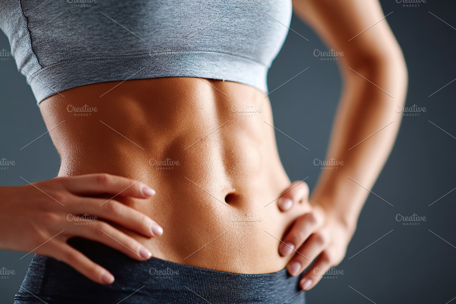 Fit young woman showcases toned abs in studio setting while posing confidently, a Sports & Recreation Photo by AlyaAnd