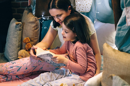 Mother and daughter reading a book in a diy tent, a Person Photo by davidpereiras