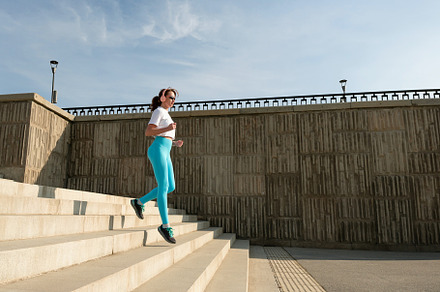 Young woman running on city streets, a Sports & Recreation Photo by Elena Vagengeim