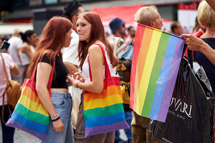 Colorful rainbow flag and LGBT women during Prague pride