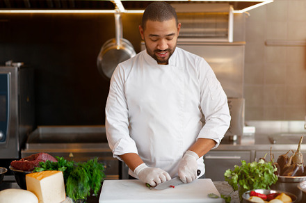 Handsome young African chef standing in professional kitchen in restaurant prep, a Person Photo by andreonegin market