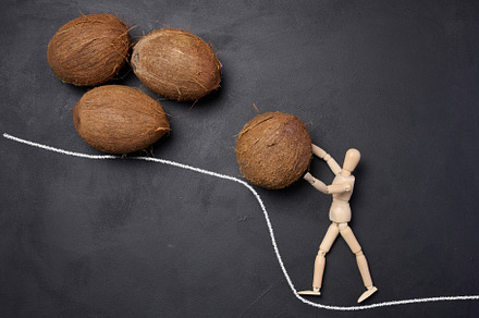 A wooden mannequin rolls a coconut up a mountain. Concept of har, an Abstract Photo by ndanko