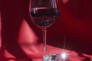 Glass of red wine and large clear diamond with smaller crystals reflecting ligh, a Food & Drink Photo by Studio ANNA