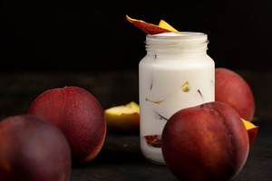 milk product with peach flavor and pieces of peach, closeup, a Photo by rsoollAI