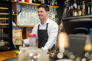 Smiling Bartender Working Behind the Bar in a Restaurant, a Person Photo by etorres69