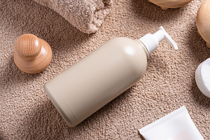 Plastic bottle with dispenser for massage oil on brown towel, a Health & Medical Photo by MDBildes